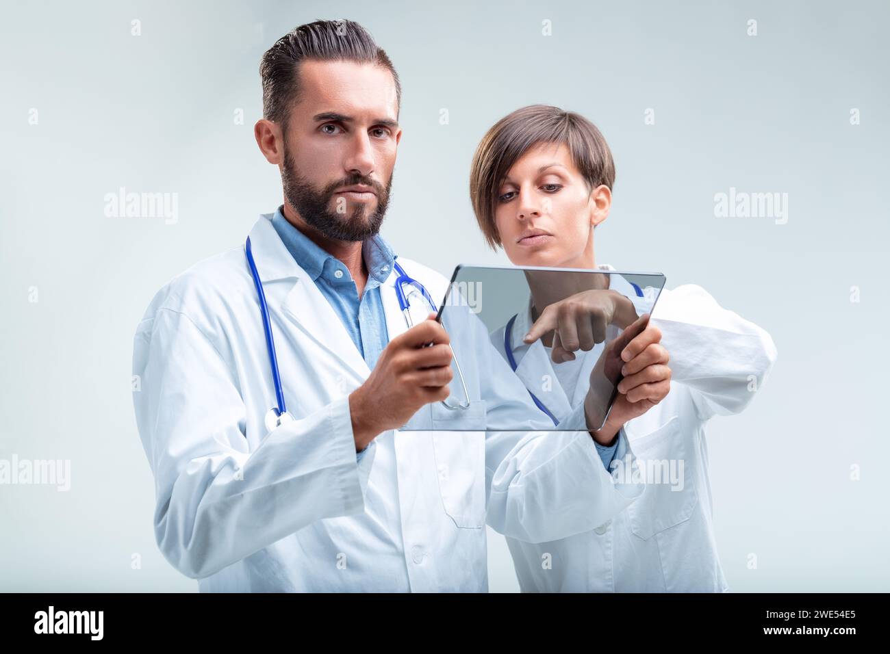 High-Tech-Gesundheitsanalyse in Aktion, wobei sich ein Mann und eine Frau intensiv auf die digitale Diagnostik konzentrieren Stockfoto