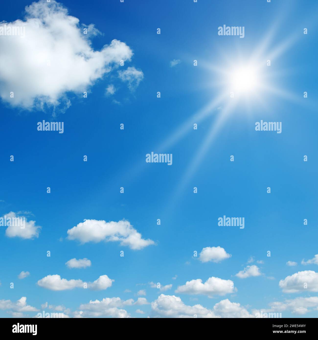 Sonne auf wunderschönem blauen Himmel mit weißen flauschigen Wolken. Stockfoto