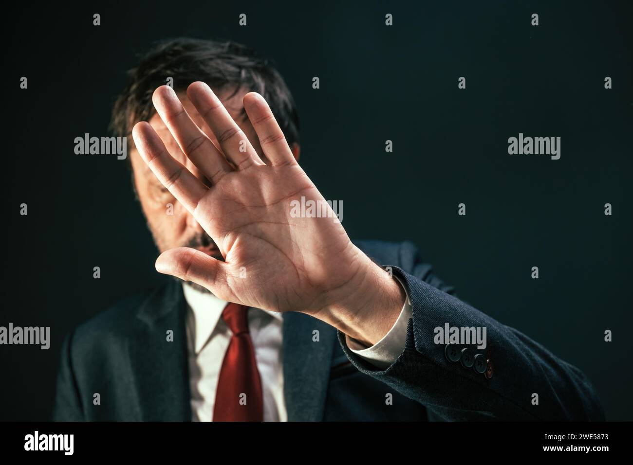 Schiefer Politiker, der das Gesicht verdeckt und sich vor Paparazzi-Fotografen versteckt, selektiver Fokus Stockfoto