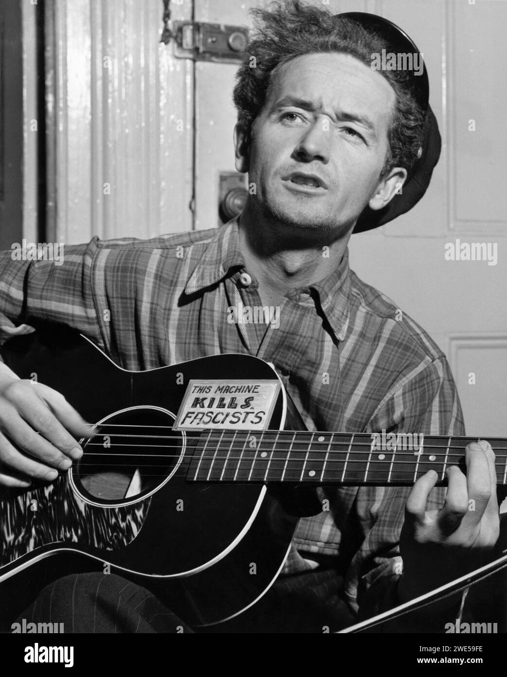 Woody Guthrie (1912–1967) ist ein US-amerikanischer Volksmusiker aus Oklahoma, dessen Arbeiten sich auf Themen des amerikanischen Sozialismus und Antifaschismus konzentrierten. Guthrie ist vielleicht am bekanntesten für das Lied This Land is Your Land. Stockfoto
