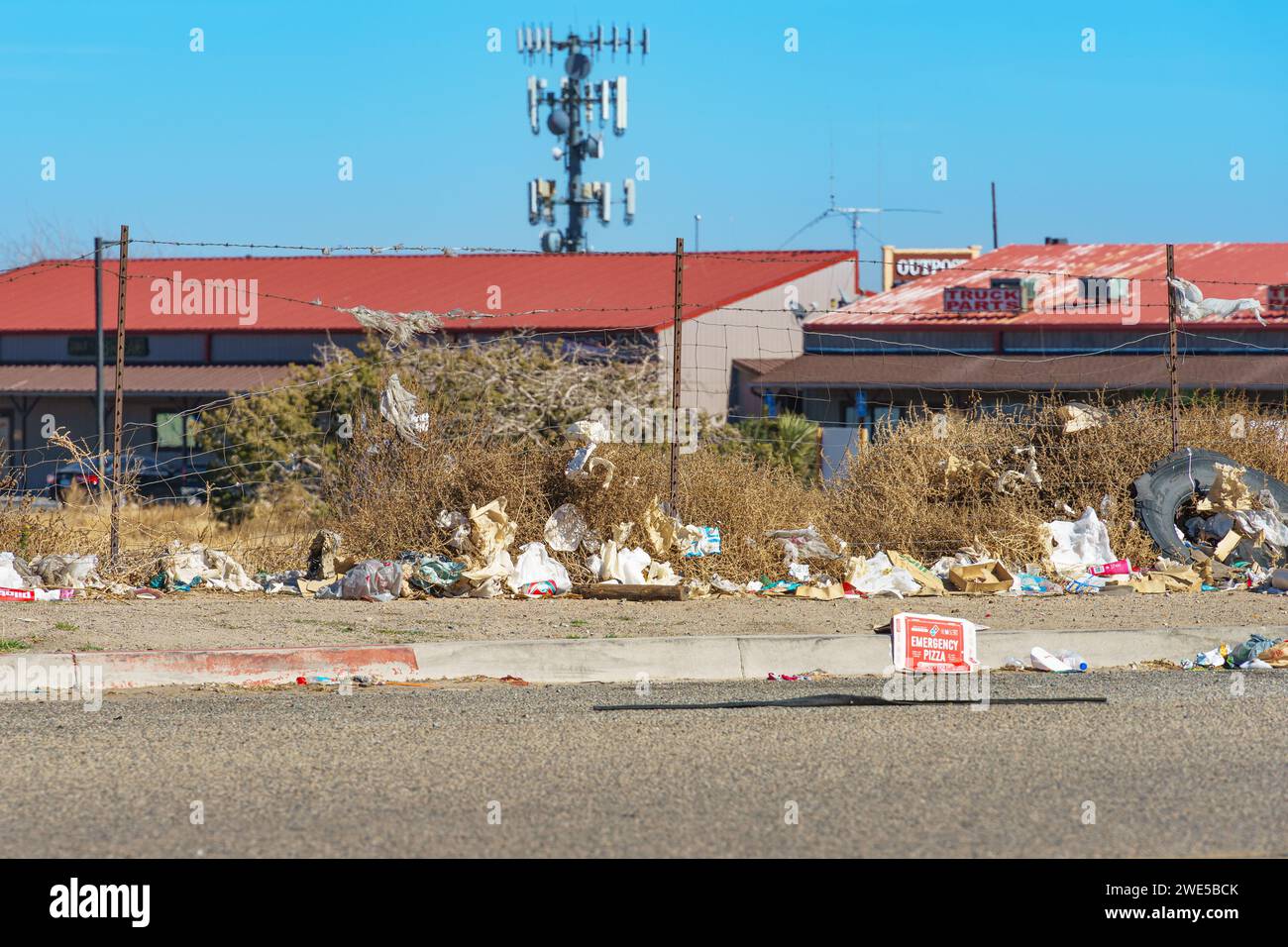 Victorville, KALIFORNIEN, USA - 18. Januar 2024: Müll stapelt sich an einem Zaun in Victorville, Kalifornien. Stockfoto