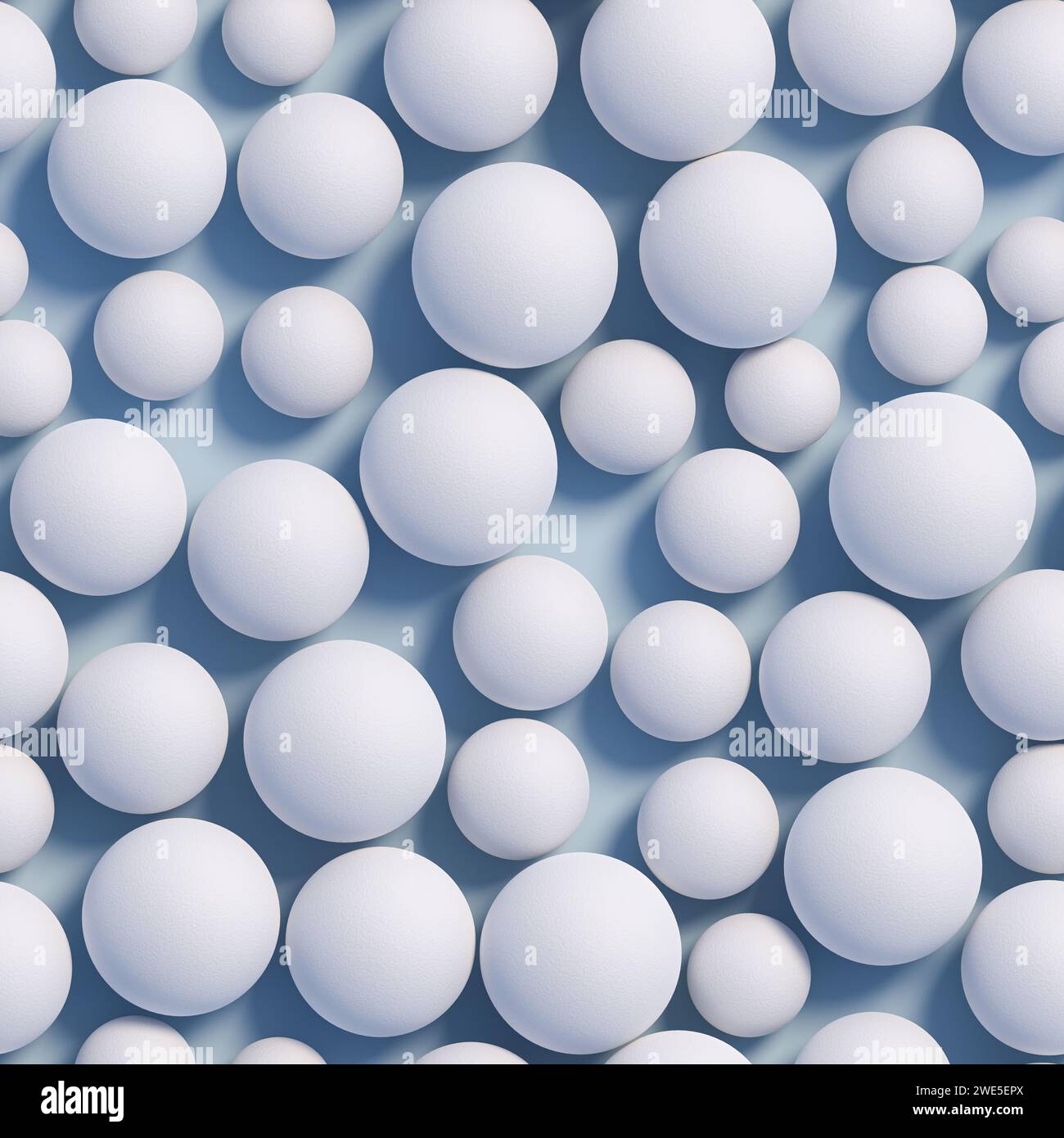 Weiße Kugeln in verschiedenen Größen mit einer rauen Oberfläche auf einer blauen Ebene. Nahtlos aneinanderreihendes Bild. Stockfoto