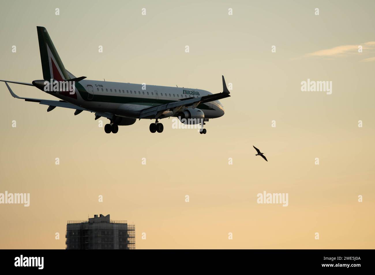 Flugzeuge landen tief über der Brücke im Osten Londons bei klarem Himmel bei Sonnenuntergang. Stockfoto