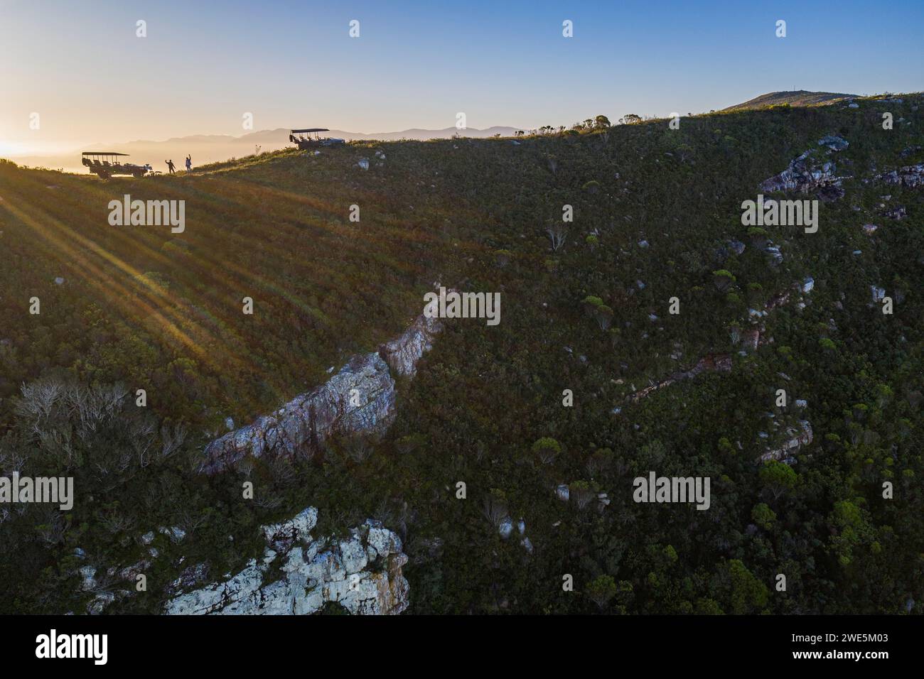 Luftaufnahme und Silhouette von Grootbos 4WD Fahrzeugen auf einem Bergrücken bei Sonnenuntergang, Grootbos Private Nature Reserve, Westkap, Südafrika Stockfoto