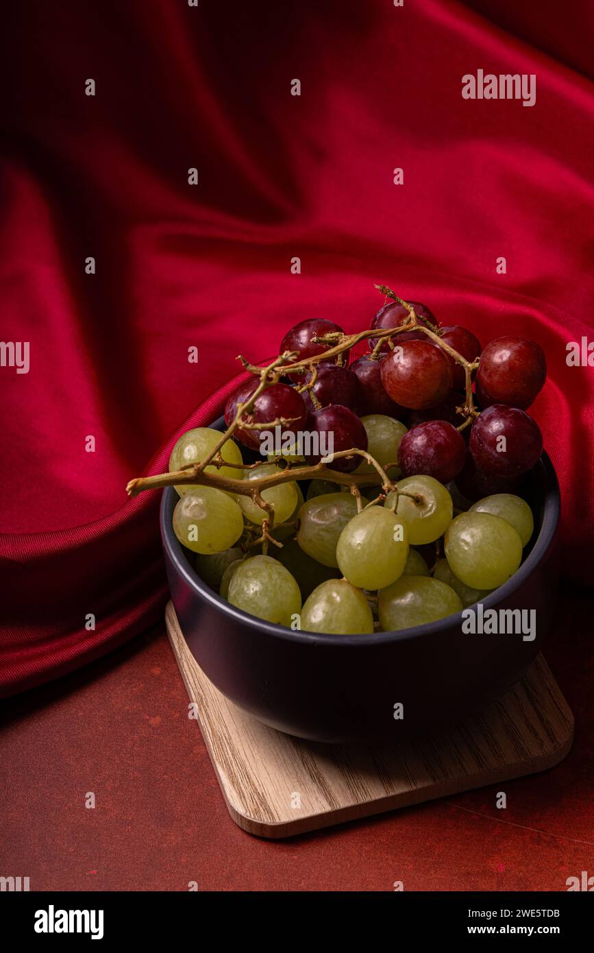 Schüssel mit Trauben mit seidenem Textil als Hintergrund Stockfoto
