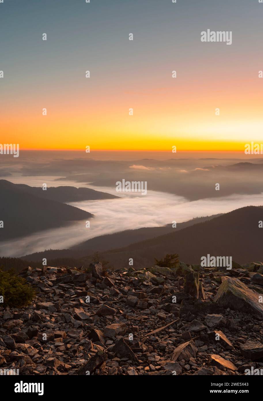 Malerische Berglandschaft bei Sonnenaufgang mit niedrigem dichtem Nebel in einem Bergtal Stockfoto