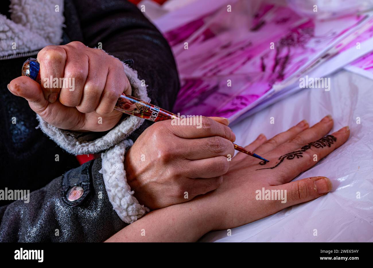 Henna Tattoo wird auf den Finger der linken Hand aufgetragen. Stockfoto