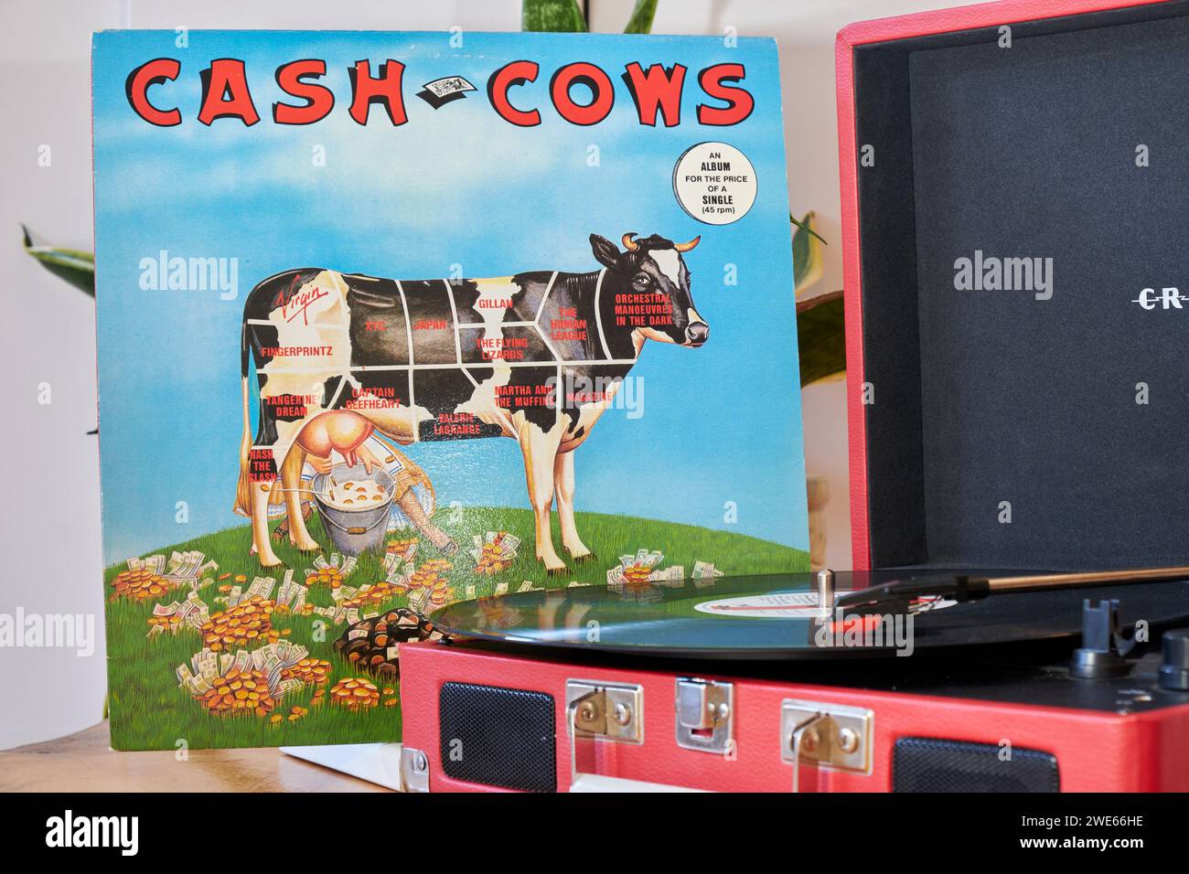 Roter Crosley-Rekordspieler im Retro-Look auf Holztisch, mit Cash Cows Canadian New Wave-Compilation aus den 80er Jahren auf dem Turntable Stockfoto
