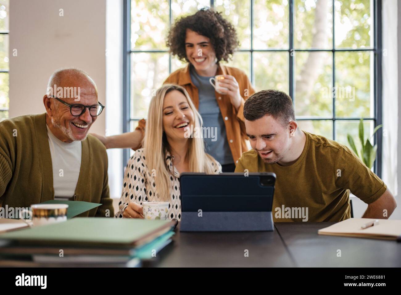 Person mit Behinderung, die mit Kollegen in einem inklusiven Gemeindebüro arbeitet Stockfoto