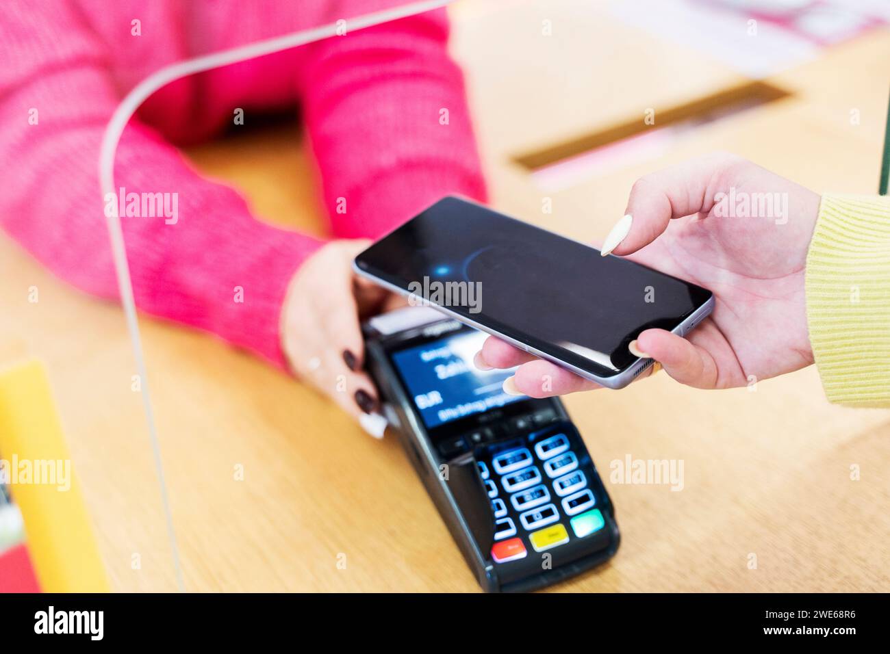 Frau, die per Smartphone bezahlt Stockfoto