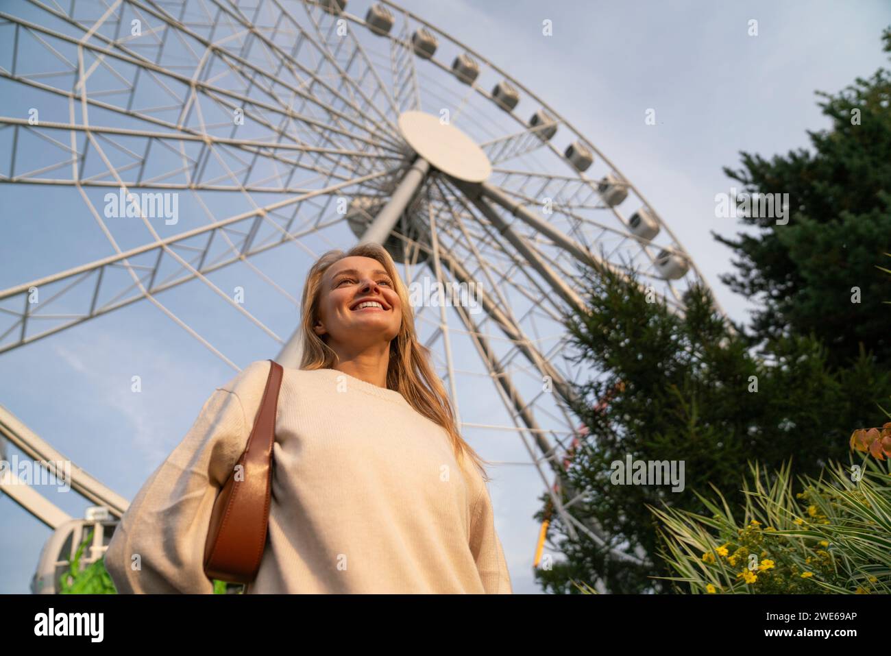 Glückliche Frau, die vor dem Riesenrad steht Stockfoto