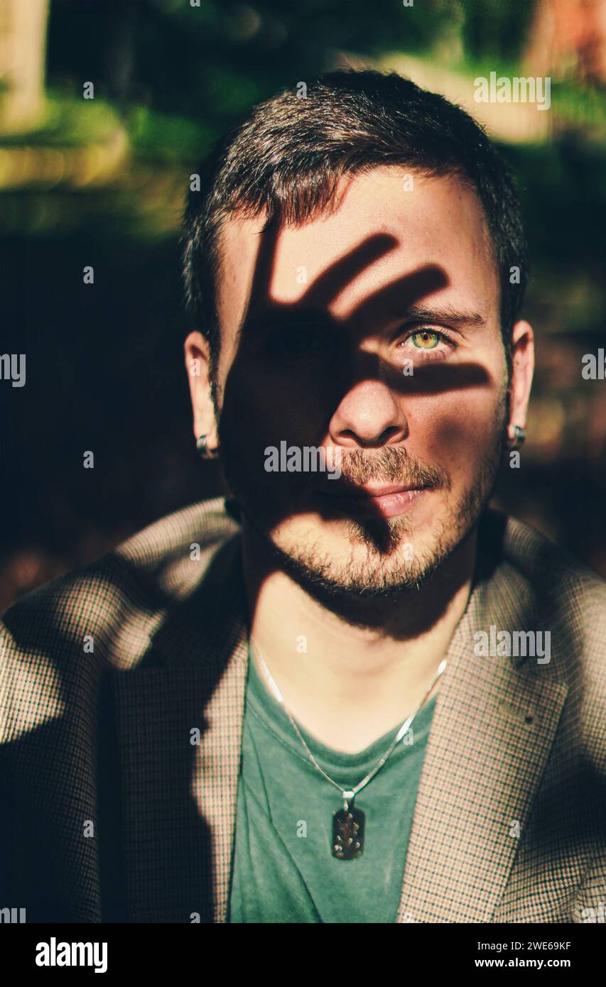 Das Gesicht des Mannes mit einem Schatten der Hand Stockfoto