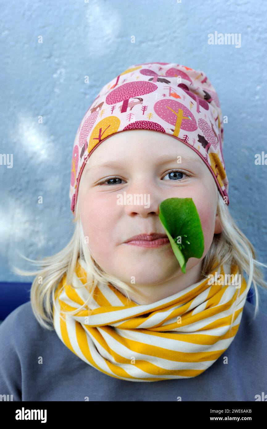 Porträt eines kleinen Mädchens mit Blatt im Mund Stockfoto