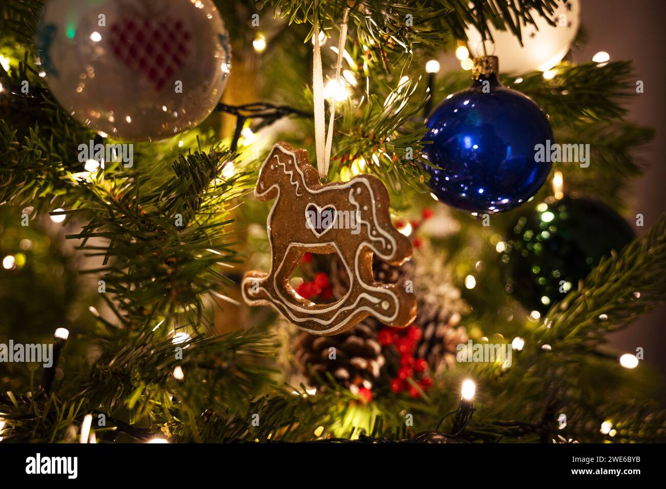 Hölzernes Pferdespielzeug hängt zu Hause am Weihnachtsbaum Stockfoto