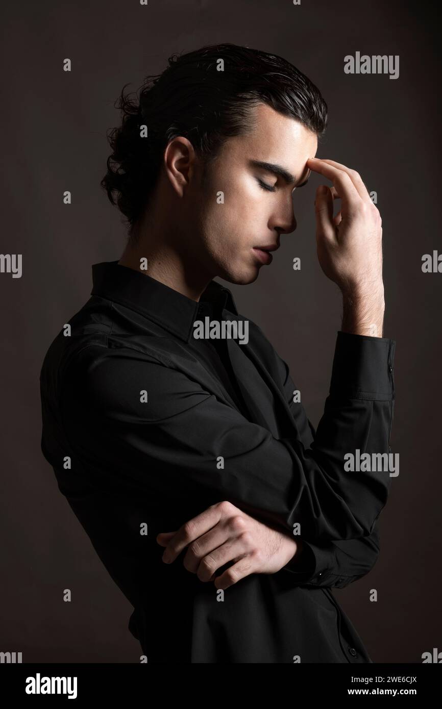 Gestresster junger Mann mit schwarzem Hemd Stockfoto