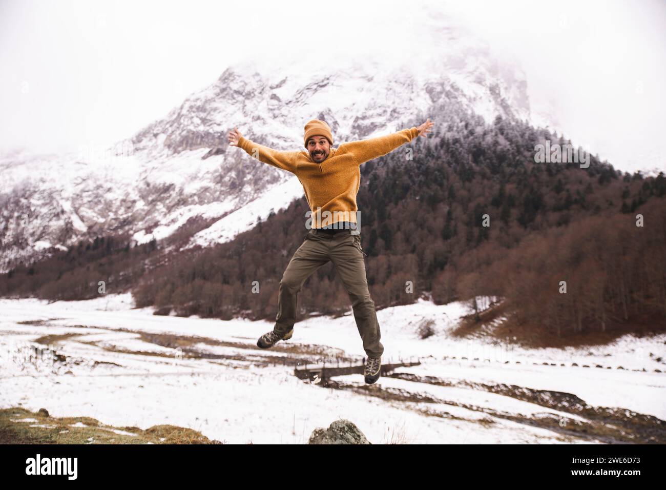 Ein lächelnder Mann springt vor den Pyrenäen, Katalonien, Spanien Stockfoto