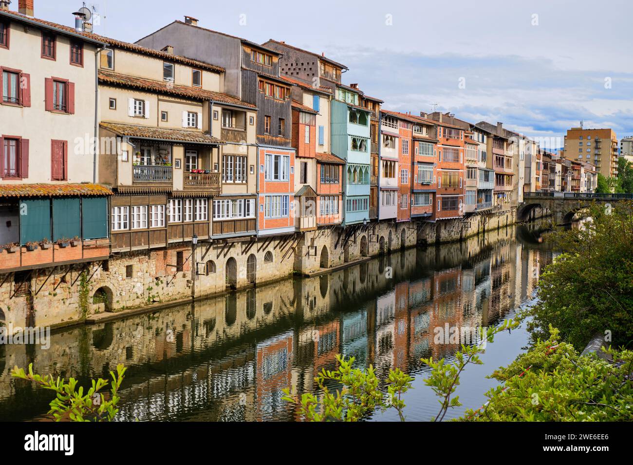 Blick auf die Castres-Architektur auf Häusern entlang des Flusses Agout. Abgewinkelter Blick von der Seite des Flusses mit Blick auf das Haus, das zur alten Brücke führt. Stockfoto