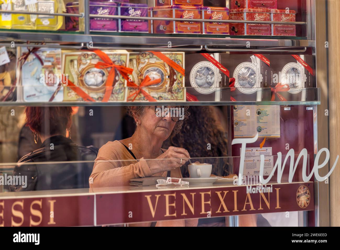 Eine schöne, alte Dame genießt eine Tasse Kaffee in einer Bar in Venedig, Italien Stockfoto