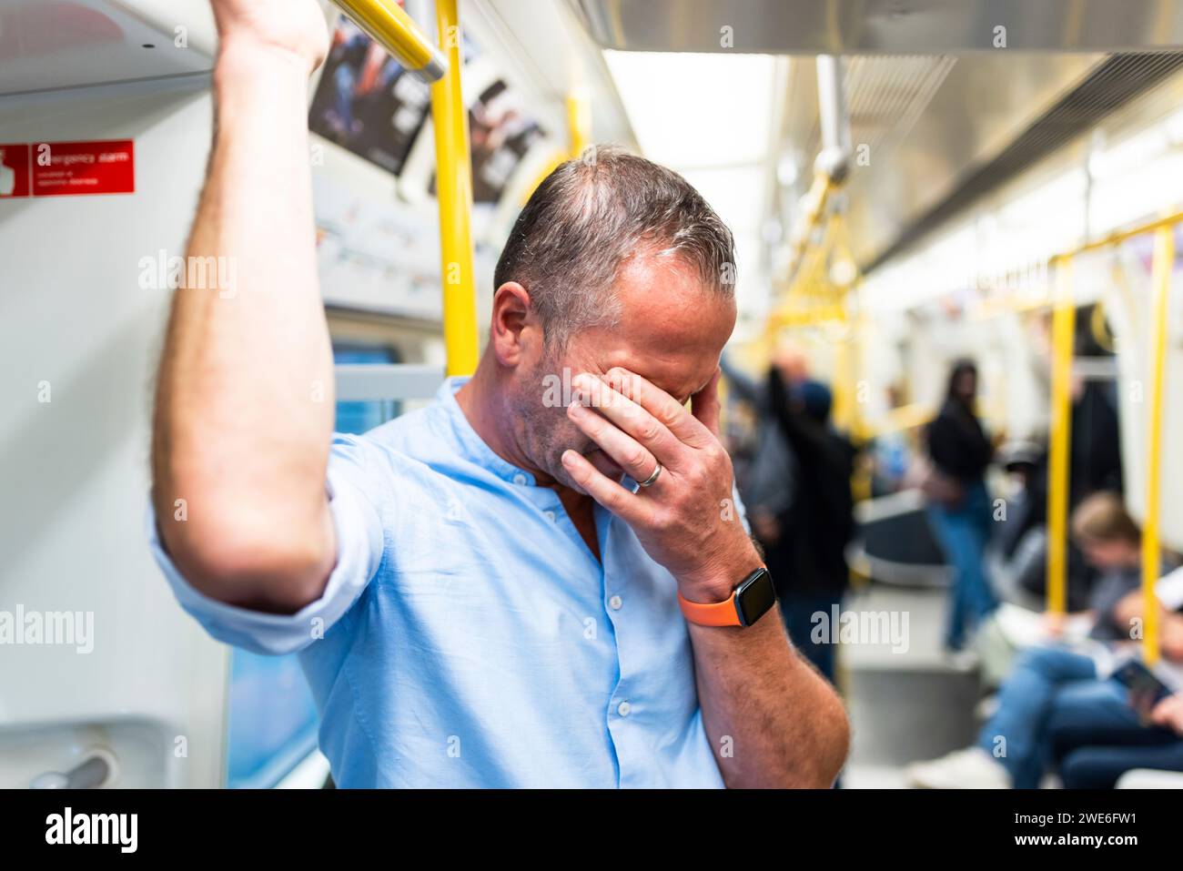 Müder Geschäftsmann, der durch den Zug pendelt Stockfoto