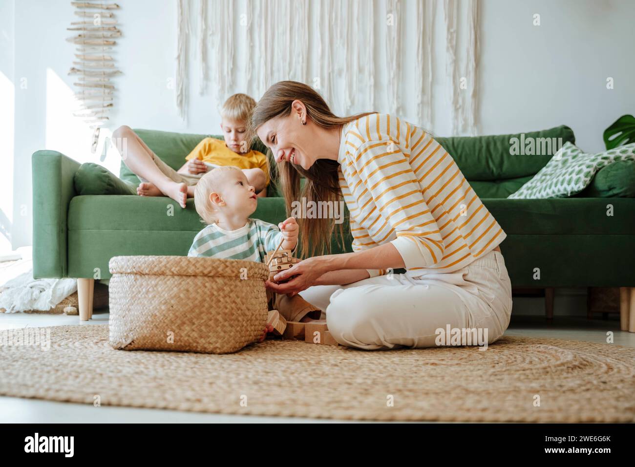 Mutter und Sohn spielen mit Holzspielzeug im Wohnzimmer Stockfoto