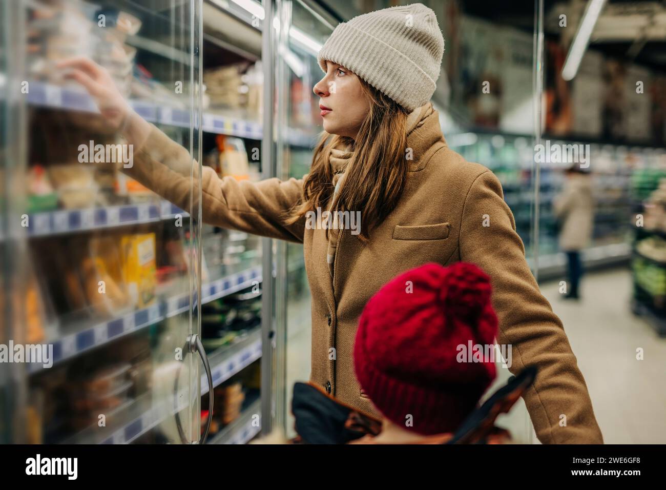 Eine Frau, die mit ihrem Sohn Lebensmittel im Supermarkt kauft Stockfoto