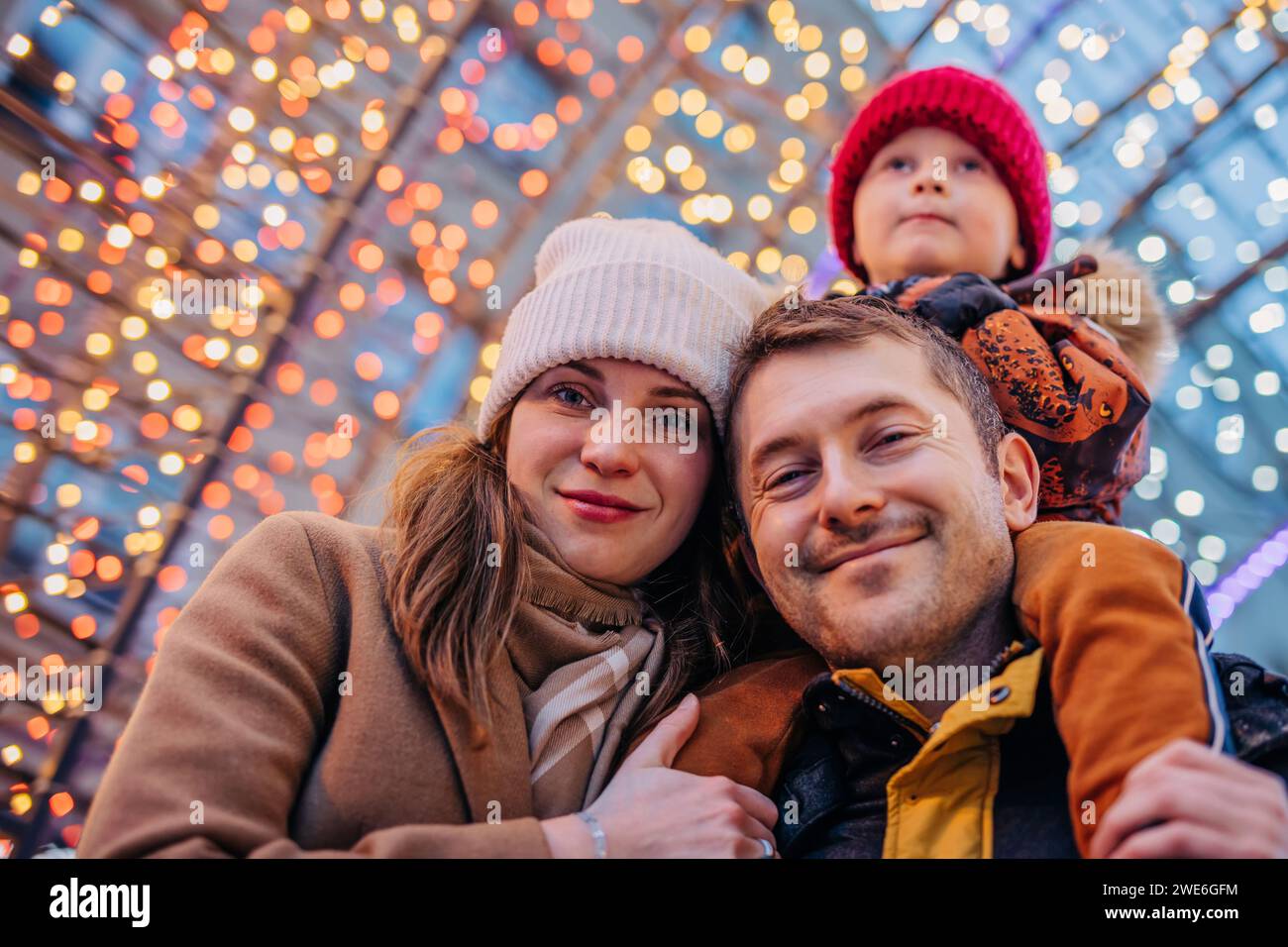 Glückliche Familie, die gemeinsame Freizeit auf dem Weihnachtsmarkt verbringt Stockfoto