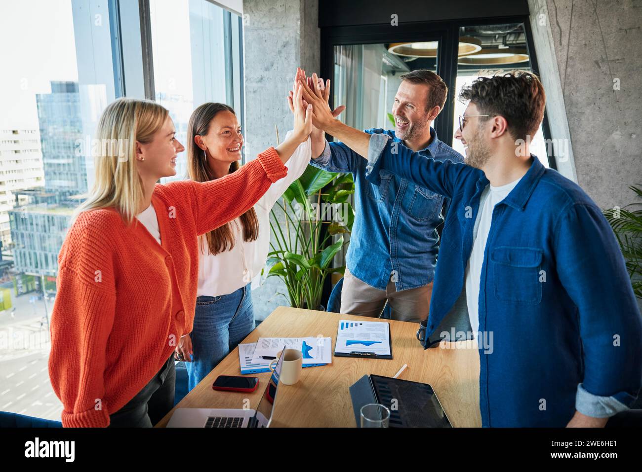 Glückliche Geschäftskollegen geben im Büro High-Five Stockfoto