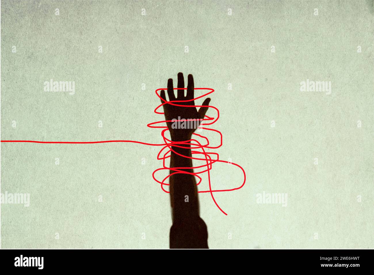 Menschliche Hand in roten, verworrenen Fäden gefangen Stockfoto