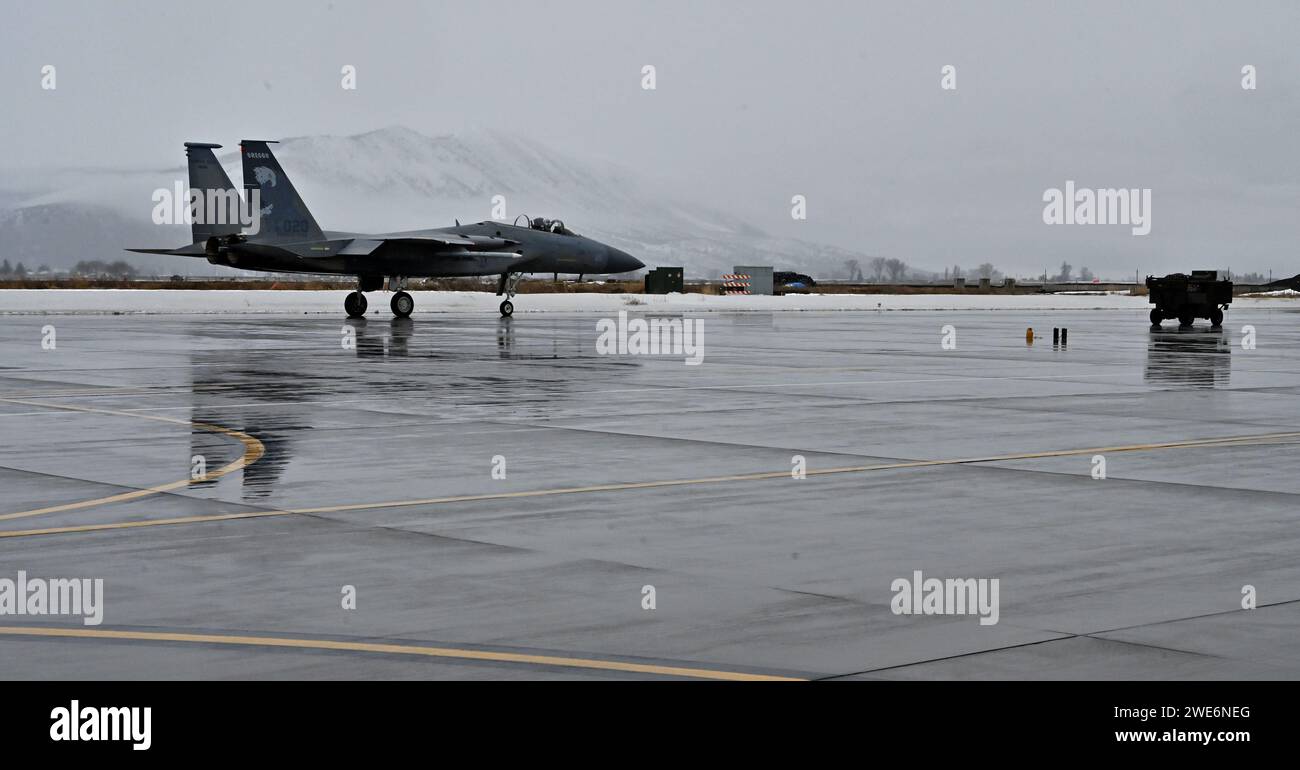 240118-Z-NJ935-0306: Kapitän der US-Luftwaffe Andrew Marshall, ein F-15C-Pilot der 550th Fighter Squadron, fährt mit seinem F-15C-Flugzeug an einem kühlen Januarmorgen über eine regendurchflutete Asphaltdecke, bevor er am 18. Januar 2024 zum nahegelegenen Range Space aufbricht, um am Kingsley Field in Klamath Falls, Oregon, zu trainieren. Er und ein weiterer Pilot sind die letzten beiden, die die F-15C Instructor Pilot-Bewertung erhalten, wenn die Air Force von der altehrwürdigen Flugzeugzelle zur F-35 übergeht. (Foto der U.S. Air National Guard von Master Sgt. Jefferson Thompson) Stockfoto