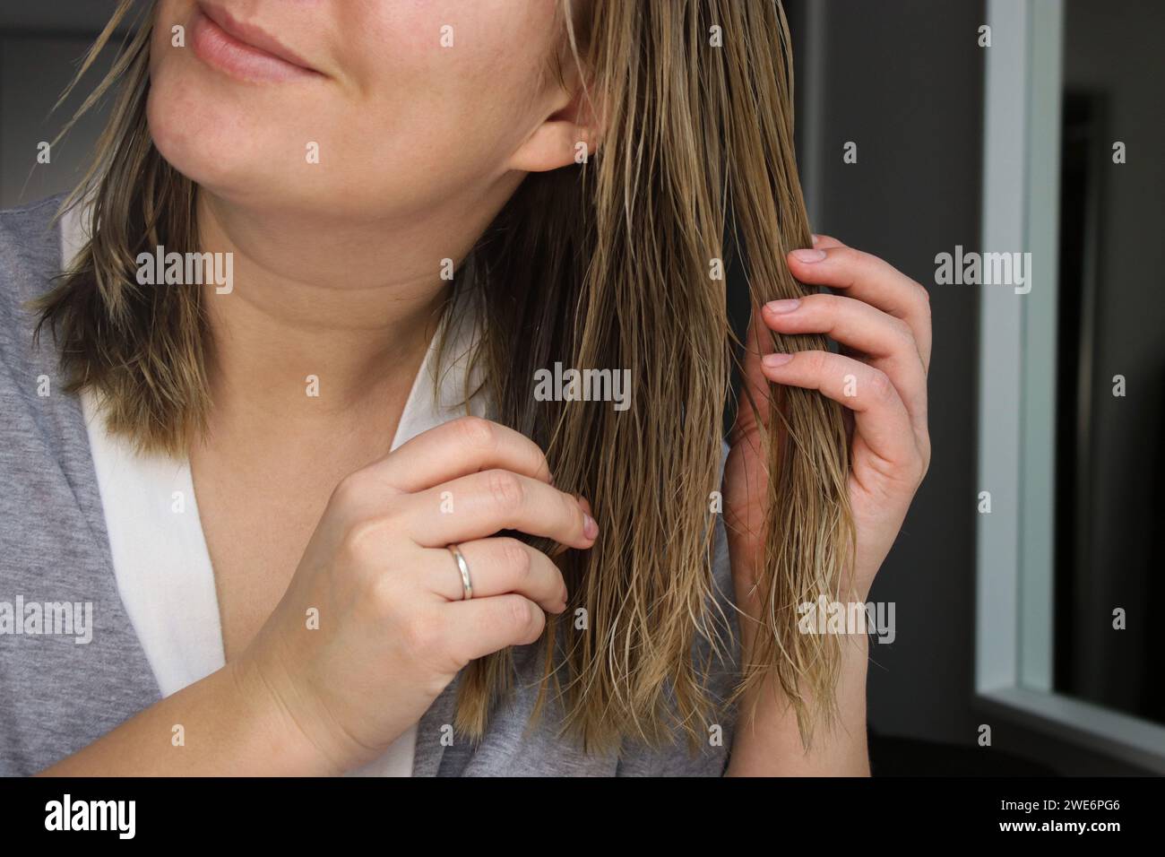 Nahaufnahme einer Frau, die die Haarmaske auf nassem Haar aufträgt Stockfoto