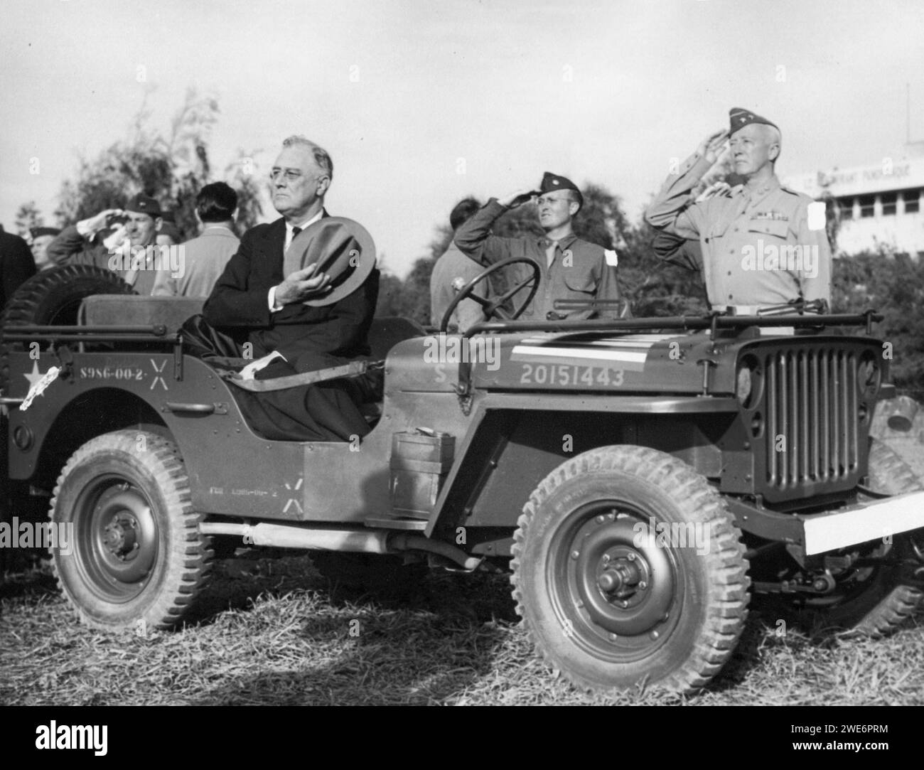 Präsident Franklin D. Roosevelt saß im Jeep mit Hut über dem Herzen und überprüfte die Truppen mit General George Patton, Casablanca 1943 Stockfoto