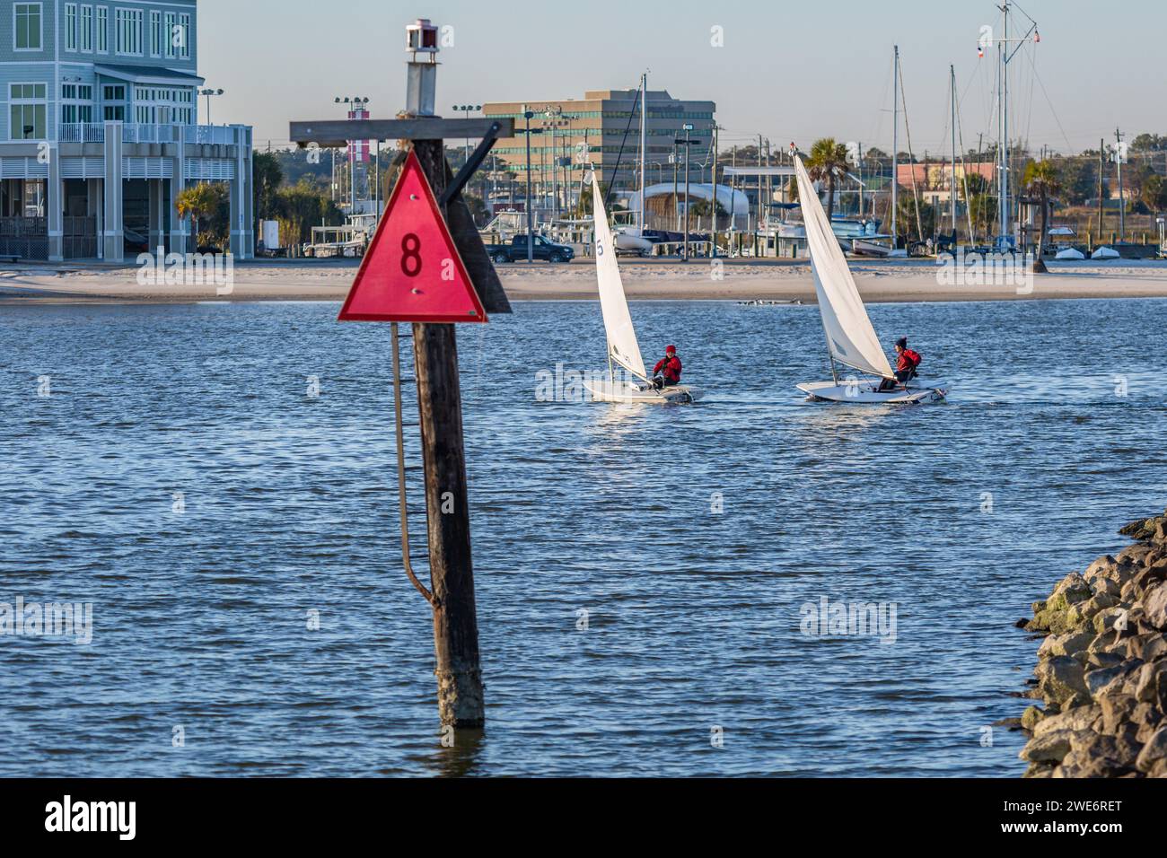 Zwei männliche Jugendliche segeln auf Laser-Segelbooten im Golf von Mexiko am Gufport Harbor in Gulfport, Mississippi Stockfoto