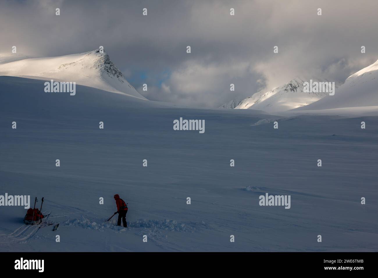 Ein Skifahrer, der im Winter ein Zelt auf dem Kungsleden Trail in Schweden, Lappland vorbereitet Stockfoto
