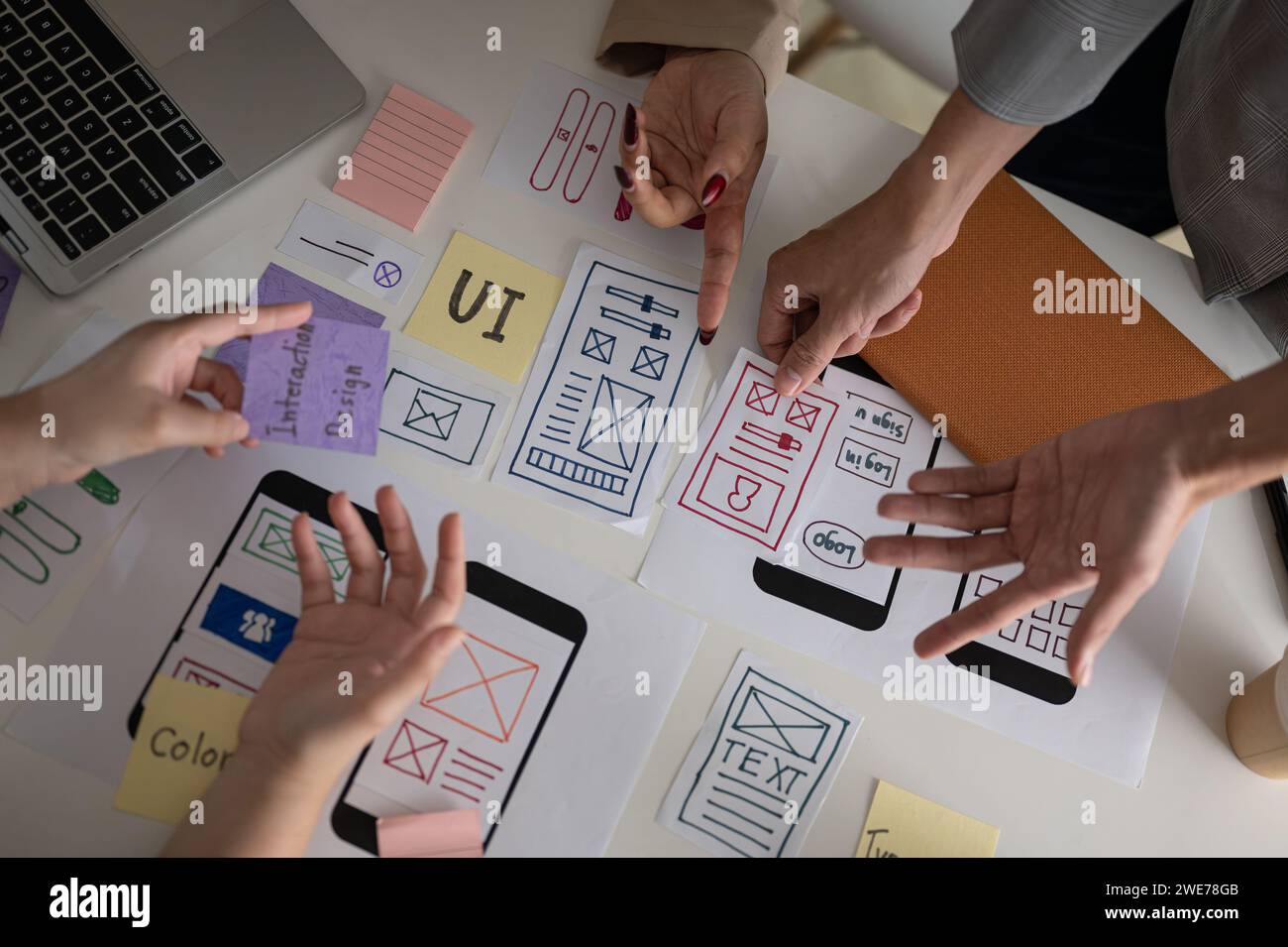 Draufsicht eines professionellen und kreativen UX-UI-Grafikdesigner-Teams, das den perfekten Prototyp für sein neues Produkt wählt, diskutiert und plant den Arbeitsauftrag Stockfoto