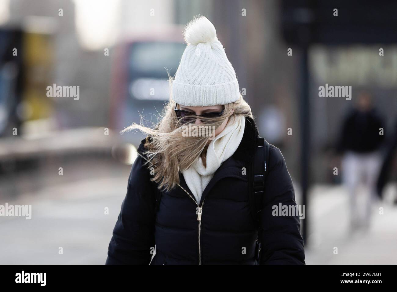 London, Großbritannien. Januar 2024. Eine Frau mit windgepeitschten Haaren überquert die Waterloo Bridge in London. Während des Sturms Isha wurden Flüge und Züge gestrichen, und es bestehen weiterhin Warnungen zur Lebensgefahr mit der Gefahr möglicher Tornados in Teilen des Landes. Quelle: SOPA Images Limited/Alamy Live News Stockfoto