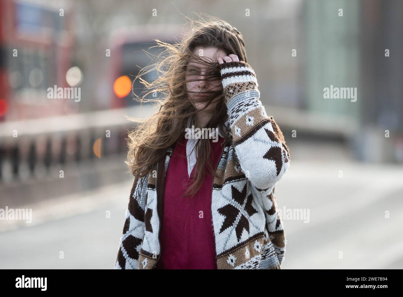 London, Großbritannien. Januar 2024. Eine Frau mit windgepeitschten Haaren überquert die Waterloo Bridge in London. Während des Sturms Isha wurden Flüge und Züge gestrichen, und es bestehen weiterhin Warnungen zur Lebensgefahr mit der Gefahr möglicher Tornados in Teilen des Landes. (Foto: Tejas Sandhu/SOPA Images/SIPA USA) Credit: SIPA USA/Alamy Live News Stockfoto