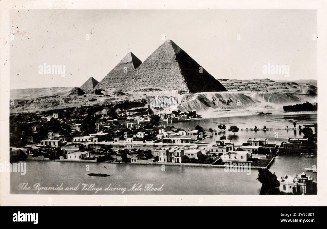 Vintage-Postkarte von Lehnert & Landrock mit dem Titel „die Pyramiden und das Dorf während der Nilflut“ wahrscheinlich 1940er Jahre, mit Anzeichen von Gebrauch und Alter. Stockfoto