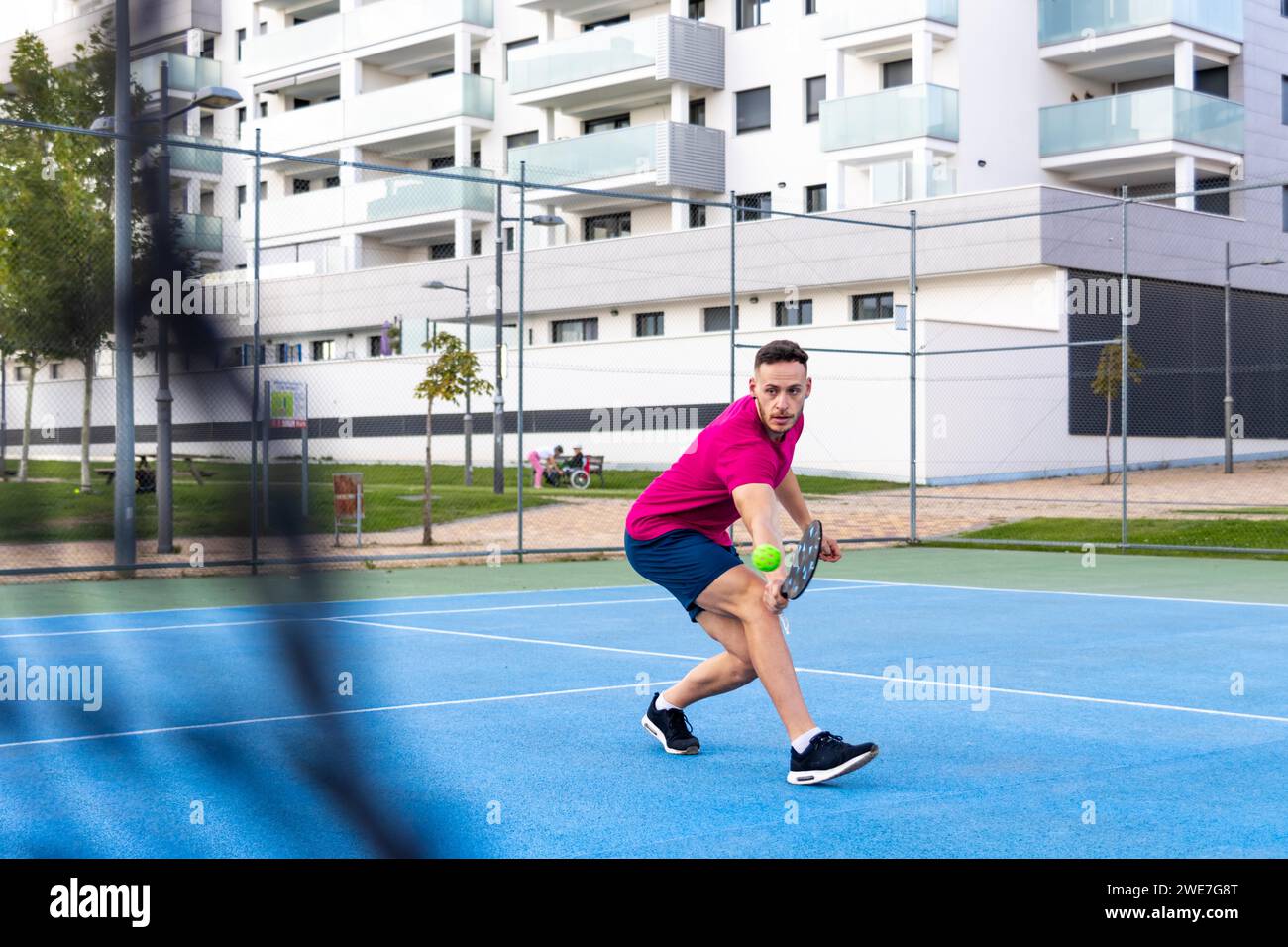 Mann spielt Pickleball-Spiel, schlägt Pickleball-Ball mit Paddel, Outdoor-Sport Freizeitaktivitäten Stockfoto