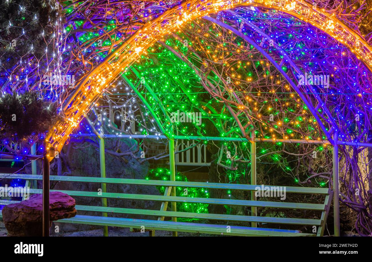 Bunte Weihnachtslichter auf Metallmarkise über der Parkbank in Südkorea Stockfoto