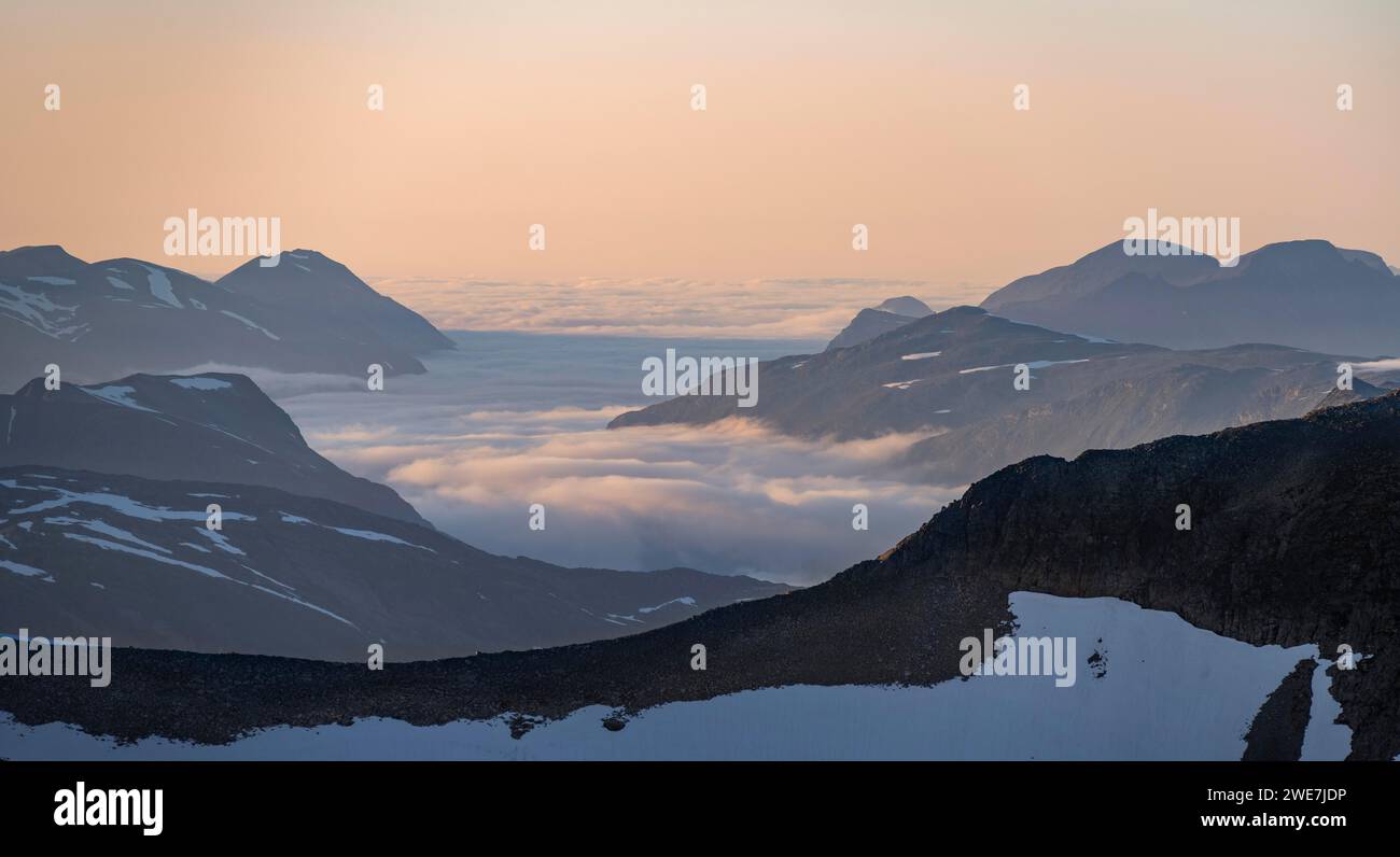 Bergpanorama mit Wolken im Tal, Berggipfel im sanften Licht bei Sonnenuntergang, Blick vom Gipfel von Skala, Loen, Norwegen Stockfoto