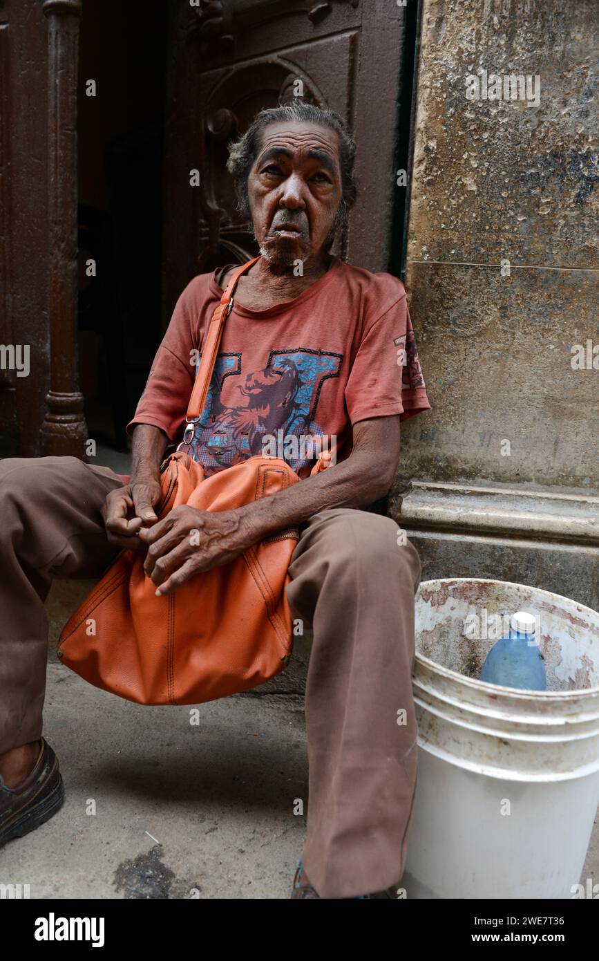 Ein kubanischer Mann, der vor seinem Haus im alten Havanna sitzt. Stockfoto