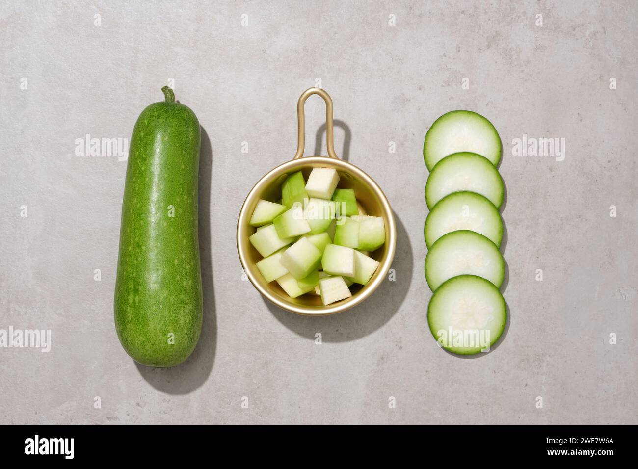 Goldener Topf mit kleinen Wintermelonenstücken. Wintermelone (Benincasa hispida) kann das Krebsrisiko reduzieren und die Augengesundheit verbessern Stockfoto