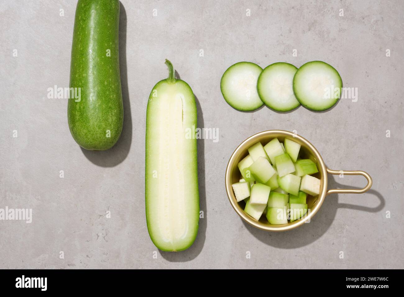 Blick von oben auf winterliche Melonenscheiben, die mit einem goldenen Topf dekoriert sind. Wintermelone (Benincasa hispida) wurde in der traditionellen chinesischen Medizin verwendet Stockfoto