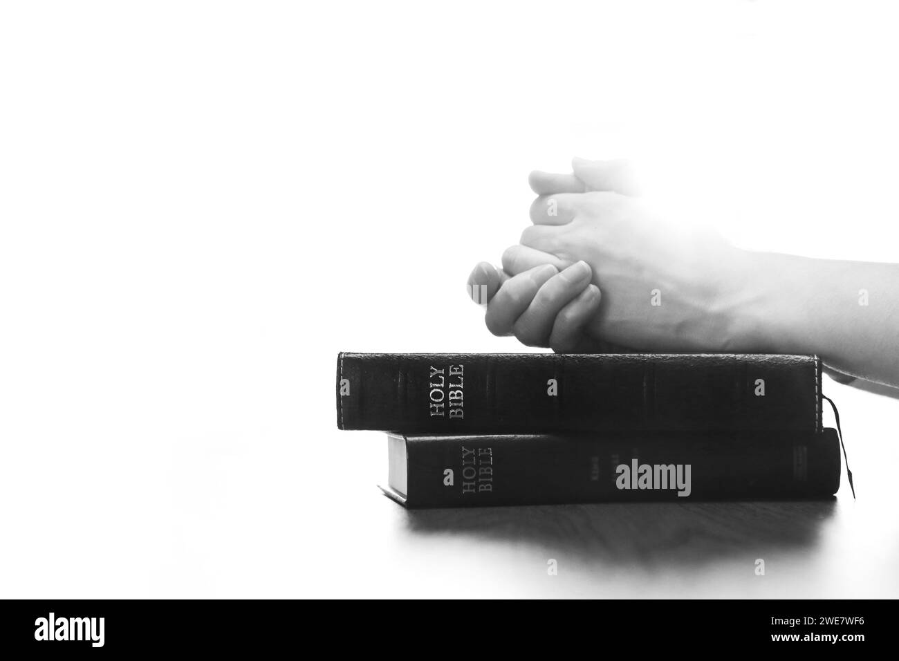 Christliche Silhouette betet und betet mit Händen auf heiliger Bibel, Religion, Glauben und Glaubensgrundlagen Stockfoto