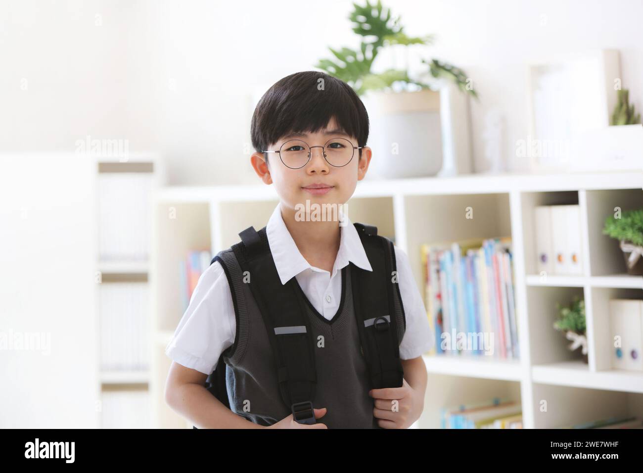 Abschluss, Eintritt und neues Semester süßer und kluger Schüler, der glücklich zur Schule geht mit einem hellen Lächeln auf seinem Rucksack. Stockfoto
