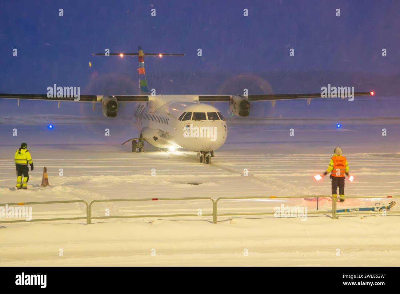 Braathens Airline ATR-72-600 Flugzeuge, die in starkem Schnee Rollen. Passagierflugzeug im Schnee am Flughafen. Zweimotorige Passagierflugzeuge bei Nacht in Umeå Stockfoto