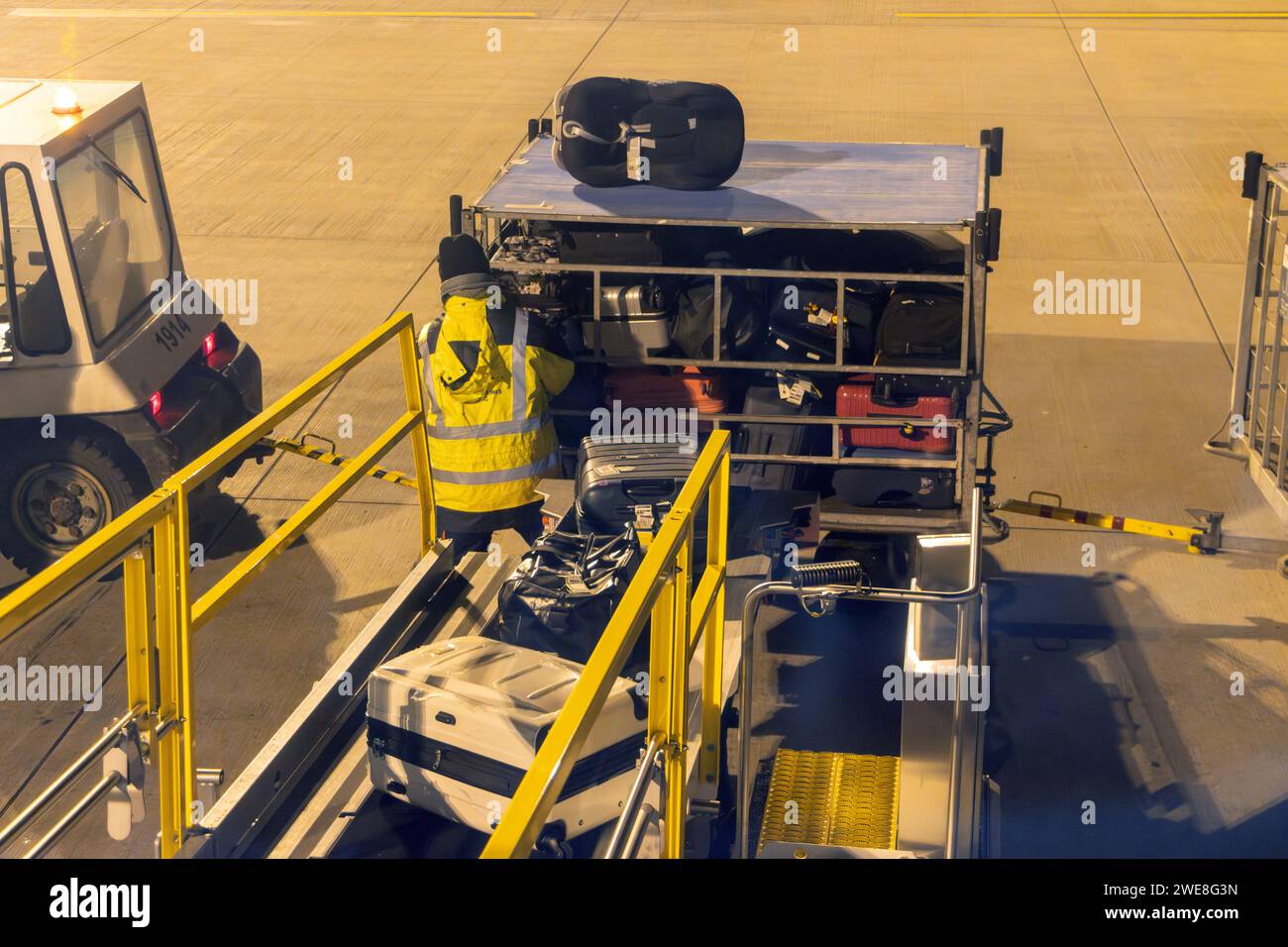 Das Gepäck wird am Nachtflughafen ins Flugzeug geladen Stockfoto