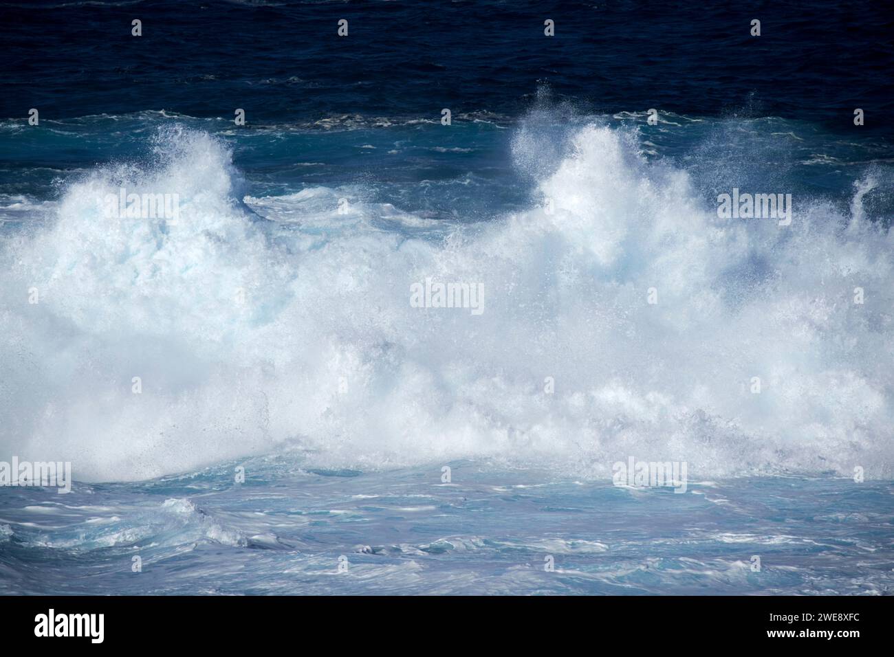 Blaue Meereswellen brechen über die flache felsige Küste an der atlantikküste der lanzarote kanarischen Inseln spanien Stockfoto