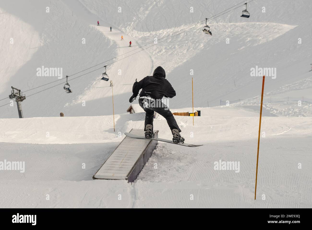 Snowpark Box Tricks. Snowboarder im Park auf einer Kiste. Winterjibbing im Snwopark in Frankreich. Stockfoto