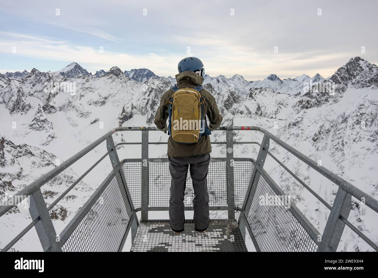 Der Mann stand an einem Aussichtspunkt in den Alpen. Snowboarder steht vor dem Hintergrund der französischen Alpen. Winter in den französischen alpen. Stockfoto